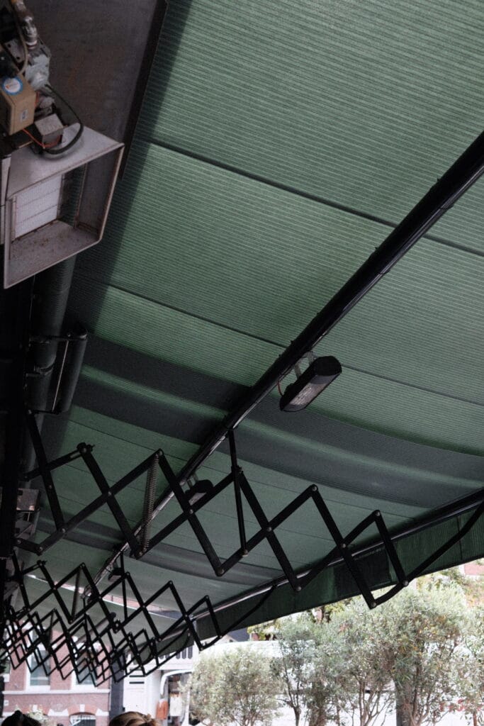 Groot knikarmscherm bij horeca terras voor zonwering en comfort voor gasten in Amsterdam