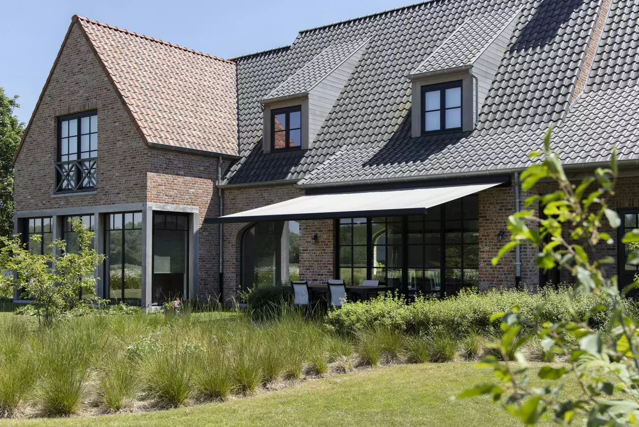 Groot knikarmscherm boven terras voor schaduw en bescherming tegen zon op warme dagen